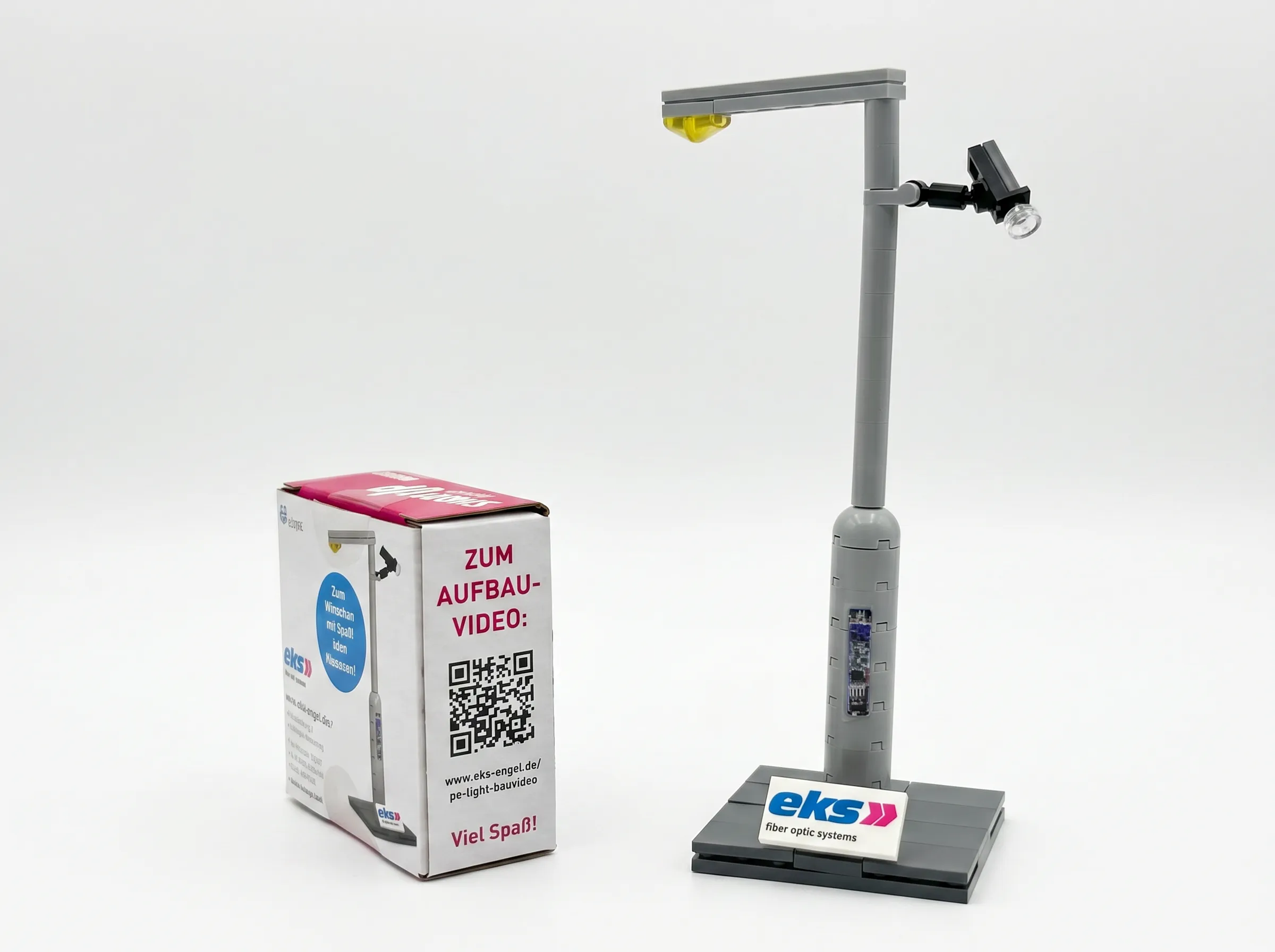 Modello in mattoncini di un palo smart con sensori, accanto alla sua confezione brandizzata