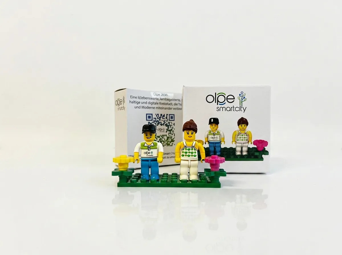 Quattro minifigure brandizzate su una base verde davanti alle confezioni di prodotto